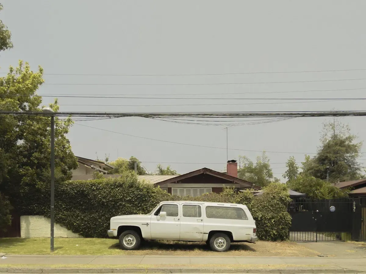 A white station wagon parked in front of a house